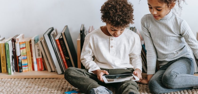 des enfants qui jouent avec une tablette